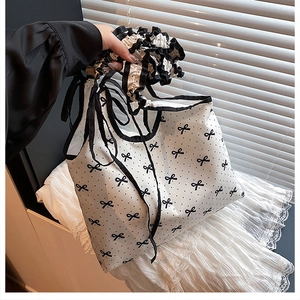 Close-up of sweet polka dot tote bag with bow tie straps and pleated ruffle handle detail