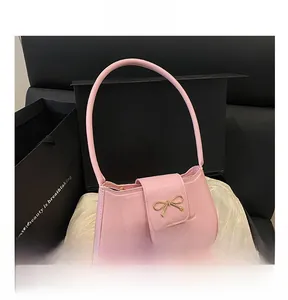 Pink leather baguette bag with golden bow buckle in elegant gift box
