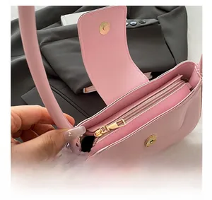 Close-up of pink PU leather bag featuring gold magnetic clasp and smooth inner zipper
