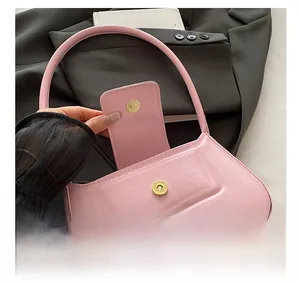 Detailed macro view of the light pink faux leather shoulder bag with gold magnetic buckle