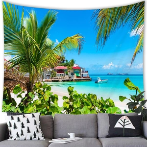 Tropical beach tapestry featuring palm trees and sea, hanging over a living room sofa