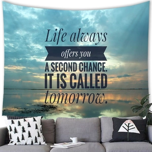 Sunset beach wall tapestry with motivational life quote hanging above a cozy sofa