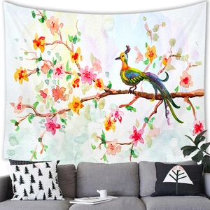 Vibrant watercolor bird and flower tapestry hanging on white wall over a grey sofa