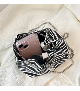Detail view of zebra print bucket bag showing spacious interior with chain strap