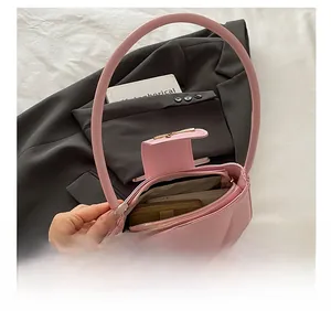 Detailed interior view of a pink patent leather shoulder bag showing large storage capacity