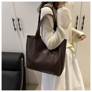 Close-up of the vintage woven texture and leather material on this dark brown tote bag