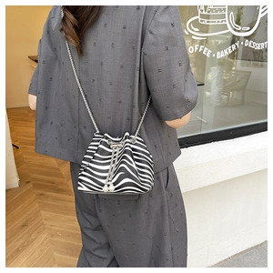 Detail of zebra pattern bucket bag with silver chain strap and pearl drawstring accents