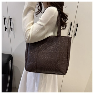 Detail of dark brown woven texture on a large minimalist tote bag for daily commute