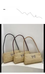 Three minimalist straw shoulder bags with bow detail in black, red and tan straps