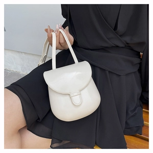 Detail view of cream white PU leather crossbody bag with flap closure and dual straps