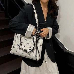 Sweet polka dot tote bag with black bows and ruffled edges shown on a model