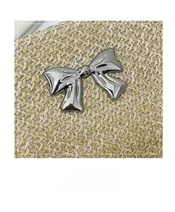 Close-up of woven straw bag texture featuring a polished silver metallic bow detail