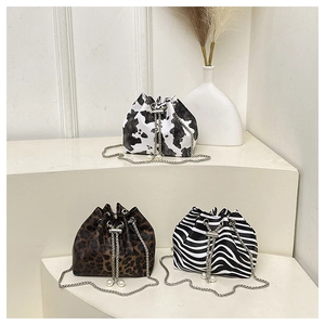 Detailed view of leopard, zebra, and cow print bucket bags with elegant pearl drawstrings