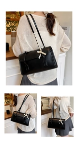Détail du sac baguette noir avec nœud crème et texture de la bandoulière tissée chic