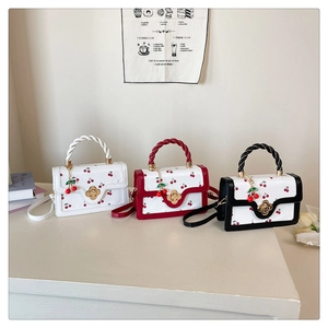 Trois sacs carrés aux motifs de cerises avec poignées tressées et fermoirs dorés