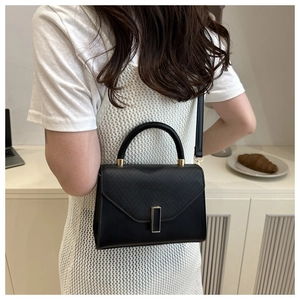 Black lizard-embossed handbag styled over the shoulder for a chic lifestyle look