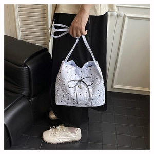 Detail der hellblauen Falten-Tote-Bag mit schwarzen Schleifen und Herz-Metallanhänger