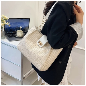 Détail du sac cabas beige tissé main avec rabat en cuir blanc et boucle dorée