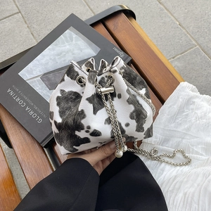 Chic cow print bucket bag with silver chain strap and pearl drawstring details