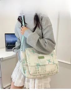 Detailed view of the butterfly pattern canvas messenger bag worn by a model