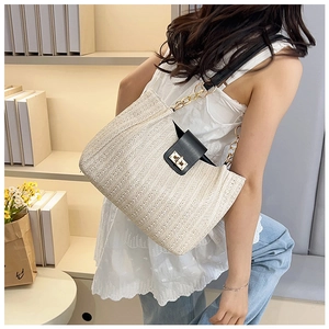 Détail du sac cabas en paille tissé main avec rabat en cuir noir et fermoir doré