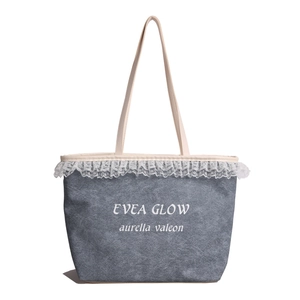 Blue denim tote bag with delicate white lace trim and minimalist brand printing