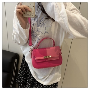 Detail of pink patchwork crossbody bag with metallic gold twist lock and top handle