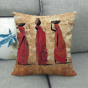 Detail of African ethnic art cushion cover with female figures on a grey sofa