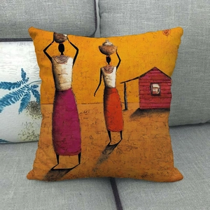 Detail of African oil painting pillow cover on sofa featuring tribal women in vibrant yellow