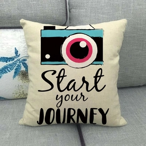 Detail of linen cushion featuring a vintage blue camera print and JOURNEY text on a sofa