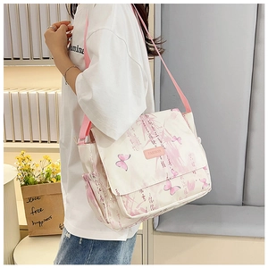 Detail of off-white canvas crossbody bag with pink butterfly prints and fashion label