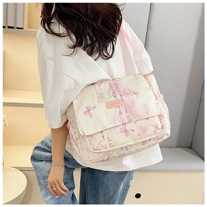 Détails de l'imprimé papillon et calligraphie sur un sac messager en toile beige