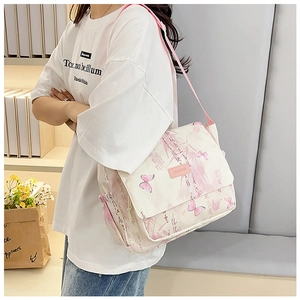 Detail of canvas bag featuring pink butterfly print and adjustable woven shoulder strap