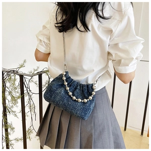 Detail of blue denim star pattern bag with silver bead handle and metal chain strap