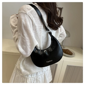 Detailed view of black semi-circular crossbody bag with Fashion logo in white