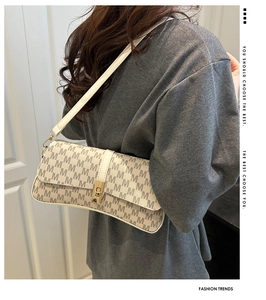 Détail d'un sac à bandoulière rétro avec motif M et fermoir tournant doré élégant