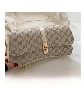 Détail du sac beige à imprimé lettres M avec fermoir rotatif en métal doré