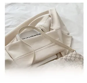 Détail du sac à main en cuir monogramme gris avec fermoir doré et bandoulière assortie