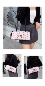 Détail du sac sous le bras rose texturé avec motifs de nœuds noirs et bandoulière en cuir