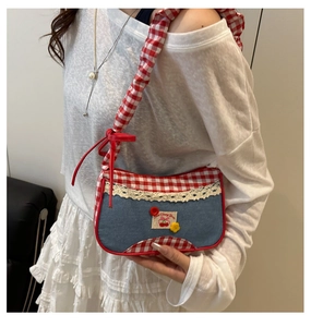 Detalle de bolso vaquero azul con tela de cuadros, parche de cereza y encaje