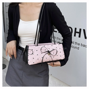 Détail d'un sac à bandoulière rose plissé avec nœud noir et motifs imprimés mignons