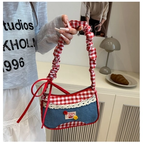 Detalle de bolso de cuadros rojos y denim con bordado de cerezas y encaje