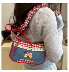 Détail du sac d'épaule en denim et vichy rouge avec dentelle et écusson cerise