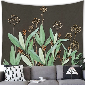 Detail of botanical wall tapestry with green leaves and gold lines over a gray sofa