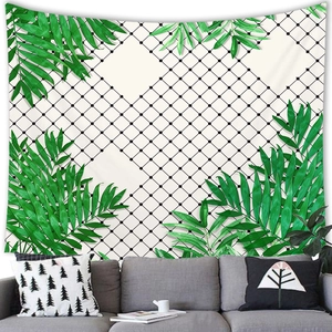 Detail of tropical leaf wall tapestry hanging above a modern sofa for home decor