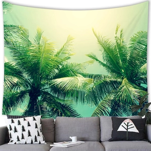 Dettaglio di un arazzo con palme tropicali appeso sopra un divano grigio per la decorazione