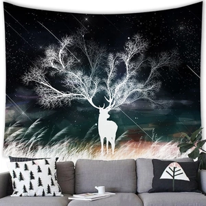 Starry night reindeer tapestry with white tree antlers hanging over a modern grey sofa