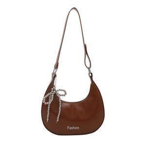 Brown leather crescent shoulder bag with silver bow chain and Fashion text detail