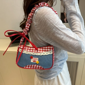 Sac à bandoulière rétro en denim avec écusson cerise et volants à carreaux sur un modèle
