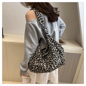 Dettaglio della borsa tote leopardata in tela indossata, mostra capienza e consistenza